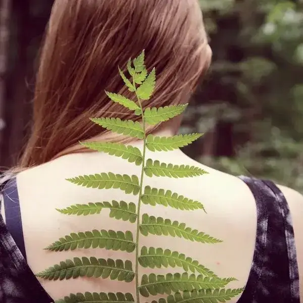 Person holding back with leaf symbolizing natural care